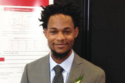 A smiling young person wearing a suit